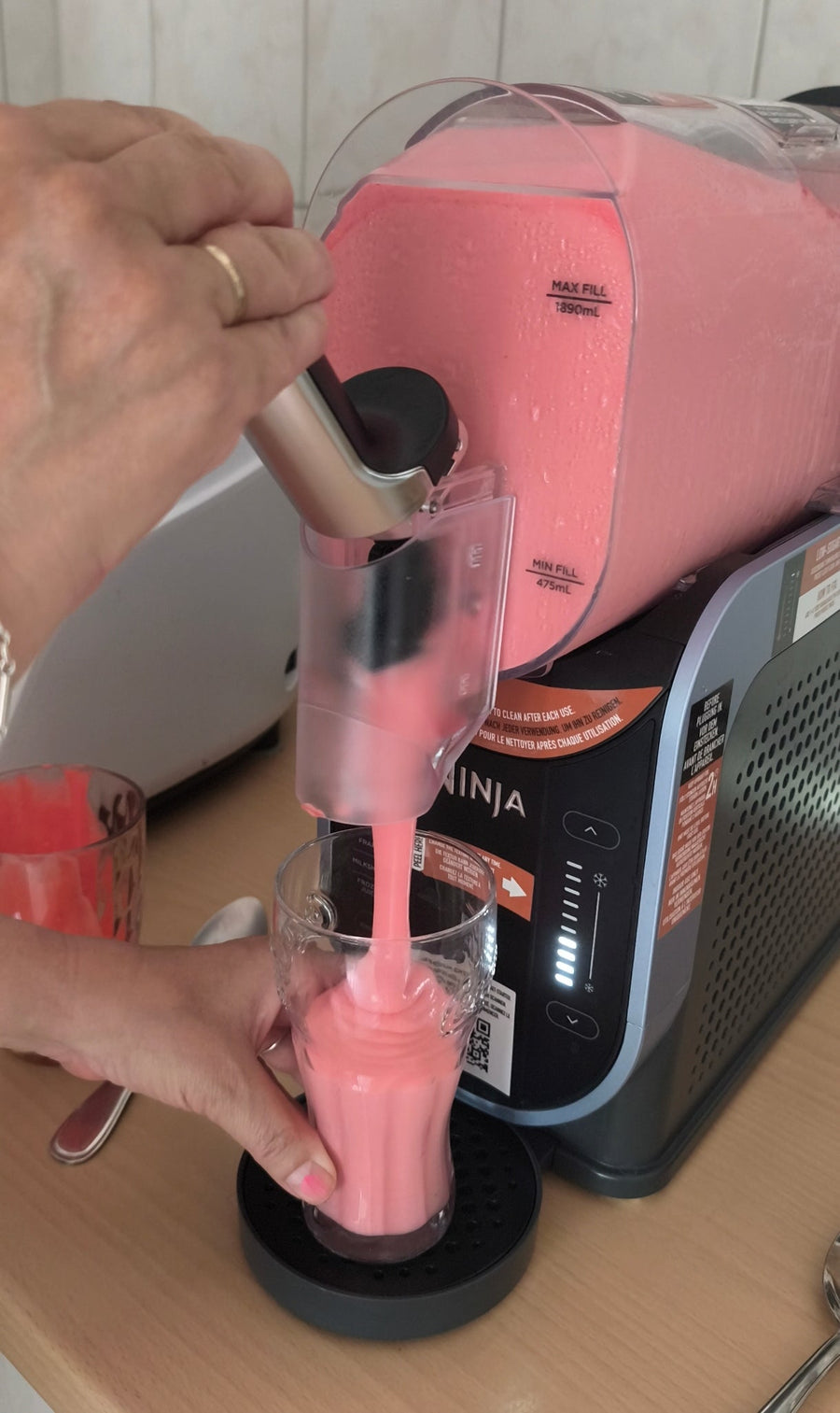 Pink strawberry slushie milkshake in a glass, with a creamy, icy texture and bright candy-like colors that inspired a future artwork.