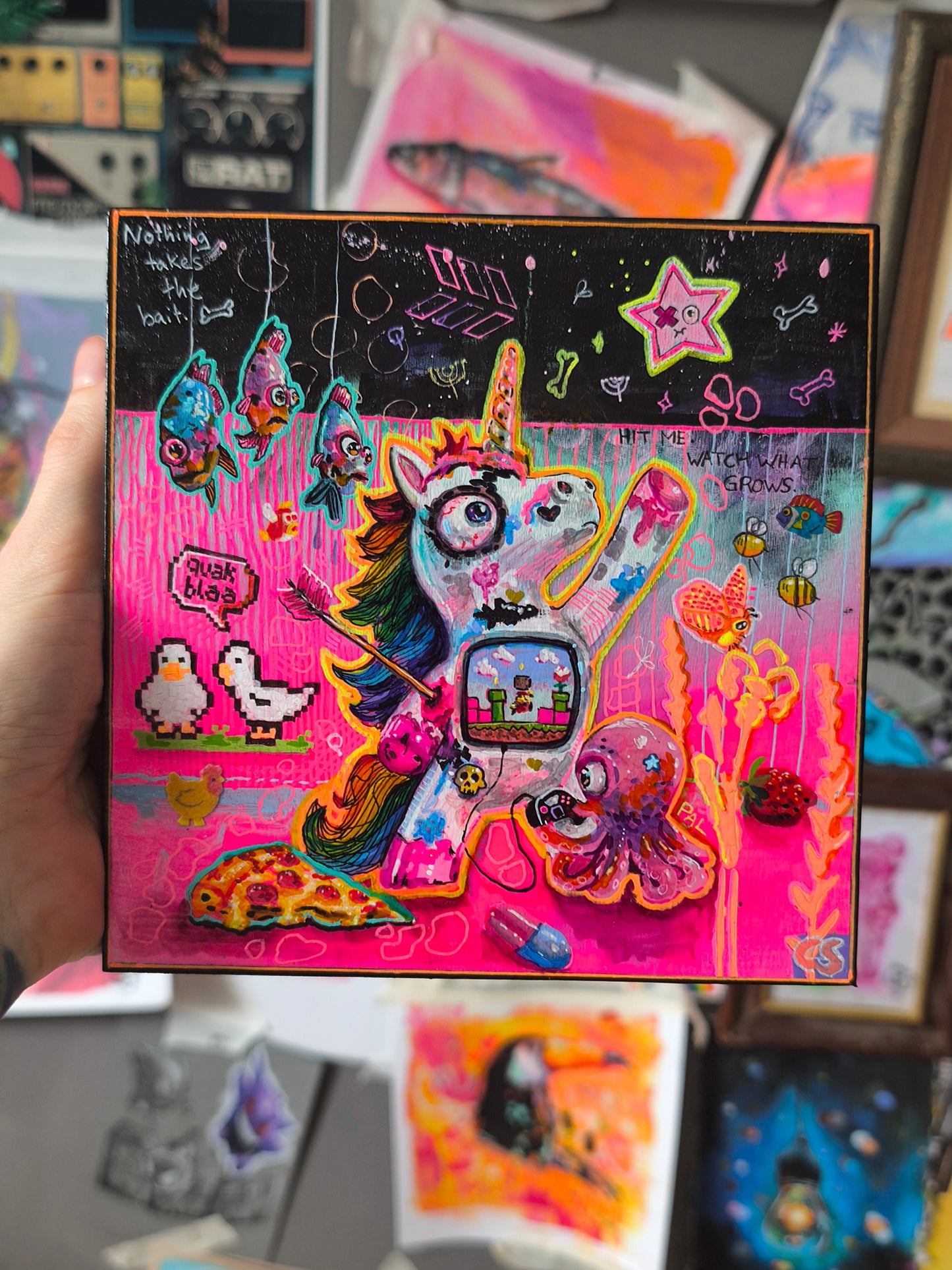 Colorful pop surreal artwork titled Ricochet featuring a whimsical unicorn hit by an arrow but still reaching toward the stars, surrounded by gossiping geese, watching fish, a friendly octopus, pizza, glitter and surreal details in bright pink and turquoise.