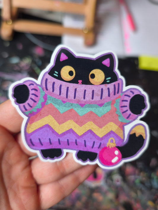 Black cat in a colourful oversized sweater