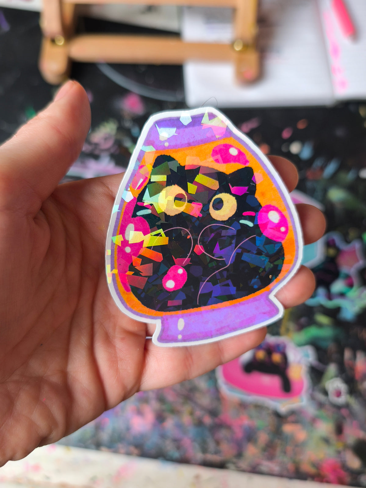 Close-up of a black cat in a colourful lava lamp with sparkling foil