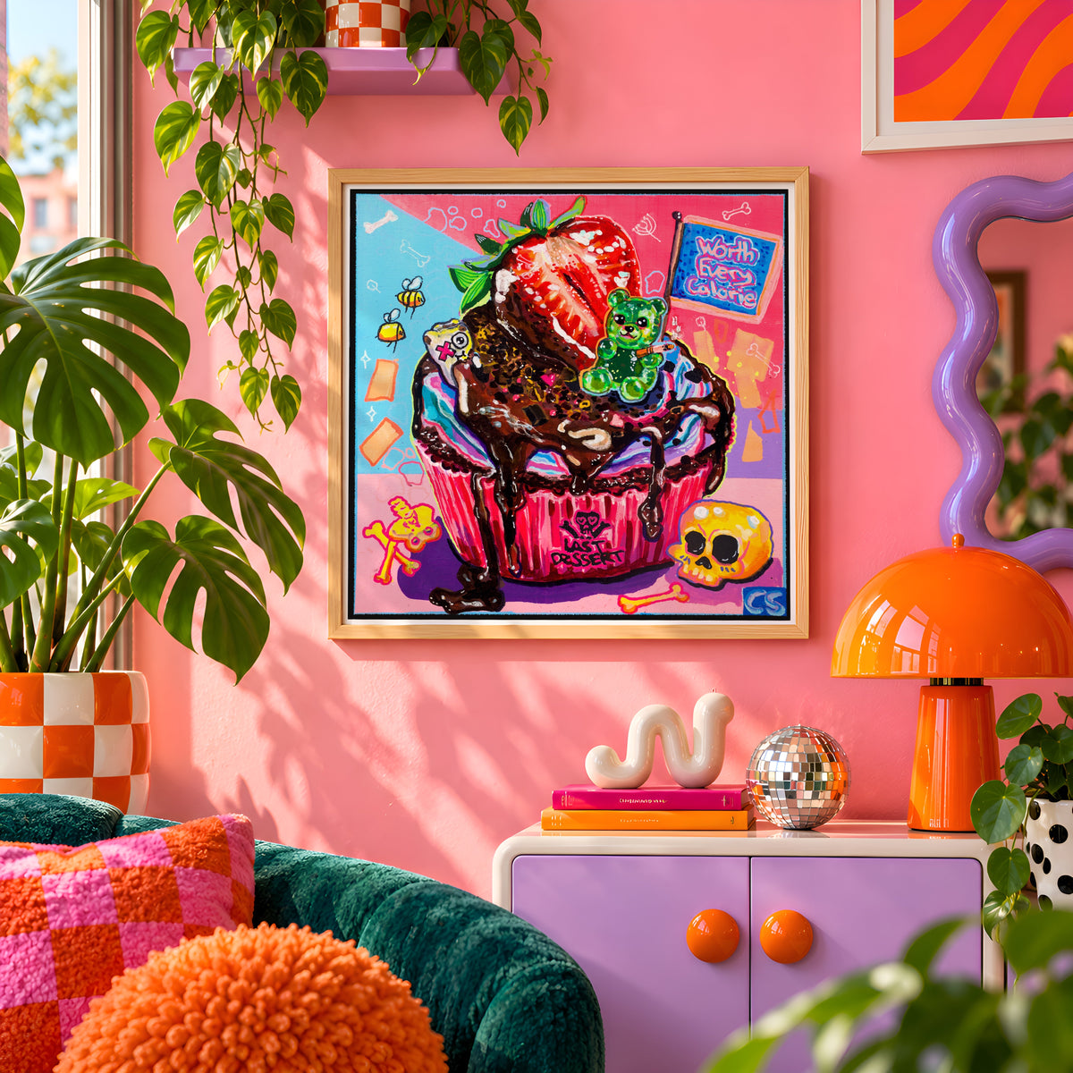 The Last Dessert wall art print framed on a pink wall, featuring a skull-topped cupcake with a gummy bear and a strawberry, Candy Decay style by Paintranger