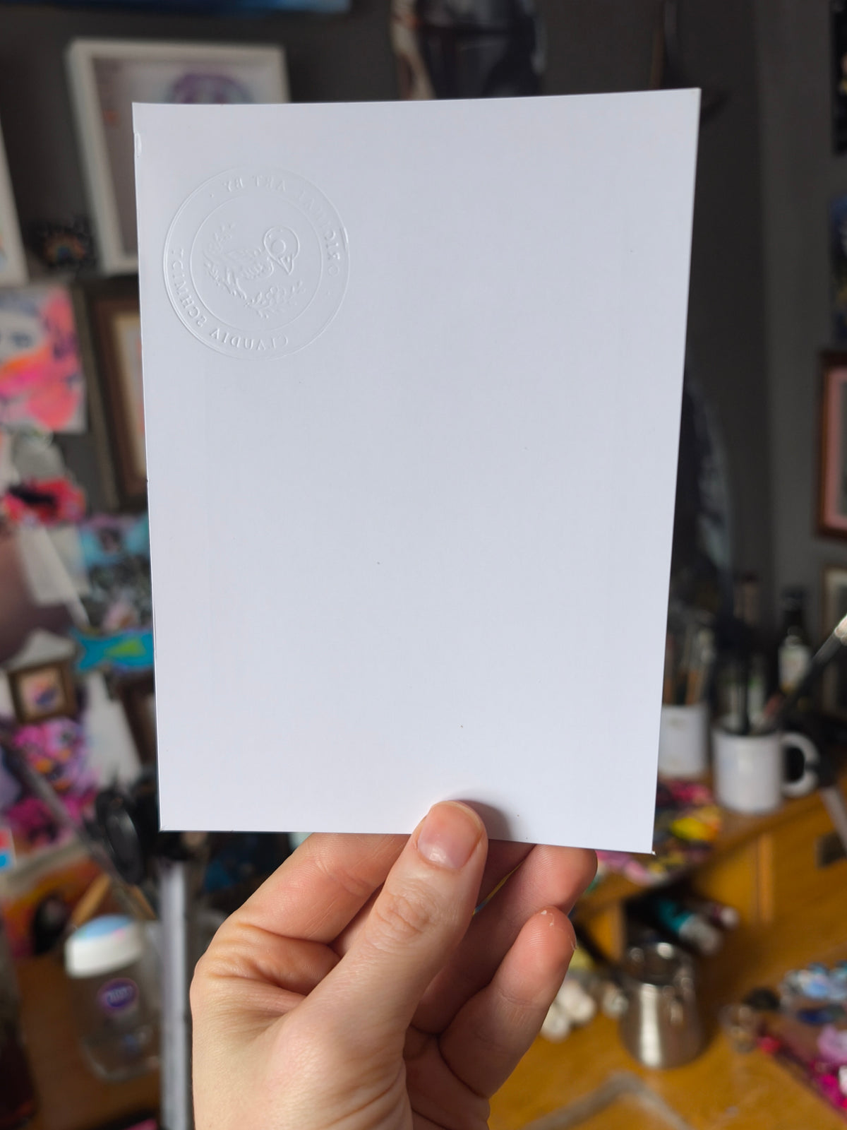 Unbedruckte Rückseite der Pizza-Tauben-Postkarte mit dem geprägten Künstlerstempel von Paintranger